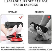 Sit-up bar trainer with black foam handles and red suction base