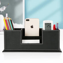 Black PU desk organizer holding phone, pens, and stationery in divided compartments.