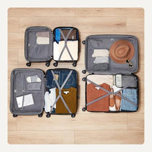 Orange hardside suitcase set laid open with packing sections and organizers inside