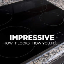 Black glass cooktop with circular burner rings and speckled buildup
