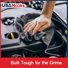 Microfiber cleaning cloth held to wipe a car dashboard surface