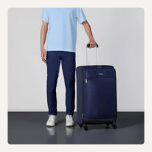 Navy softside spinner suitcase upright with telescoping handle and four wheels