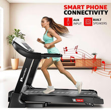 Motorized treadmill with console and handrails, shown during running with a smart device nearby.