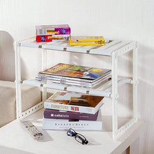 White 2-tier under-sink storage rack holding stacked books and small boxes