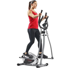 Magnetic elliptical cross trainer with handlebars and foot pedals, shown in use