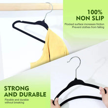 Black velvet non-slip hanger with metal hook holding a yellow garment