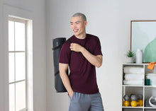 Rolled dark gray exercise yoga mat with ribbed texture and carrying strap
