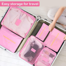 Pink mesh packing cubes inside a suitcase with zipper fronts and compartments