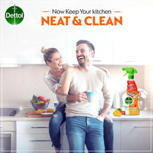 Orange Dettol kitchen cleaner spray bottle beside a smiling couple in kitchen