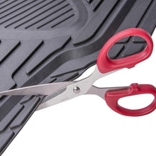 Black rubber floor mat edge trimmed with scissors, showing textured surface detail