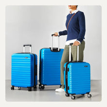Three blue hardside spinner suitcases with telescoping handles and four multi wheels