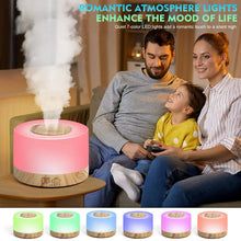 Pink LED aroma diffuser emitting mist on a bedside table with a family nearby