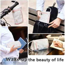 Canvas pencil storage bag with grid pattern, pink trim, shown carried and opened with contents