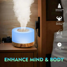 Blue-lit aroma diffuser emitting cool mist, with wood base on a tabletop
