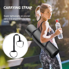 Dark gray yoga mat with carrying strap held by person during workout