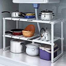 White 2-tier under-sink storage rack with cookware and storage containers on shelves