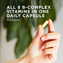 Yellow vegetable capsule held in fingers, with B-complex supplement branding