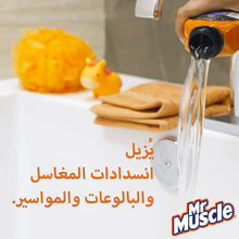 Orange Mr. Muscle drain cleaner bottle pouring clear liquid into sink, with sponge