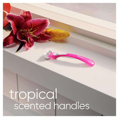Pink Gillette Venus Tropical women's razors on windowsill with tropical flower and scented handle