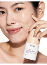 Face cleanser bottle beside model face, Anua label visible