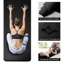 Dark gray striped non-slip yoga mat laid flat under seated stretching pose