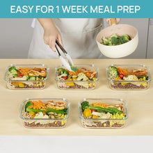 Meal prep set of clear glass containers with snap lids on a kitchen table