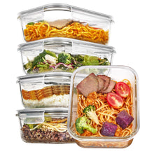 Stacked clear glass food containers with snap lids, filled with pasta, salad, and meat
