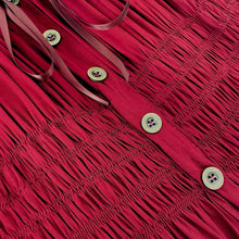 Close-up of red button-front tiered dress with ruched texture and round buttons