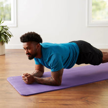 Purple yoga mat beneath a person in a plank pose, textured non-slip surface
