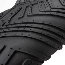 Close-up black rubber floor mat with raised grip ridges and small traction studs