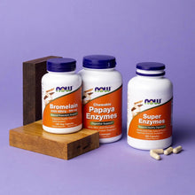 Dietary enzyme supplement bottles on a wooden block with loose capsules