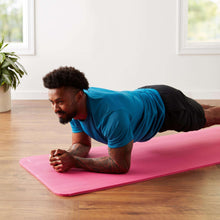 Pink yoga mat for floor exercises, supporting a forearm plank position