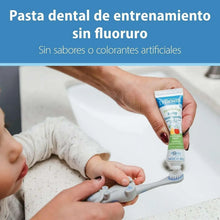 Dr. Brown's fluoride-free baby toothpaste tube in use with training toothbrush