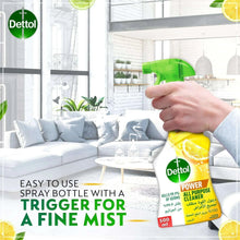 Hand holding Dettol all-purpose cleaner spray bottle, yellow with green trigger, 500 ml