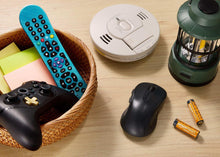 Alkaline AA batteries near a remote and other small household electronics