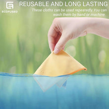 Hand holding double-sided cleaning cloth, yellow microfiber with orange-stitched edges