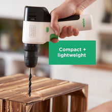 Black+Decker Reviva 12V drill with green handle drilling wood, compact design