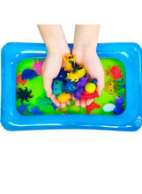 Hands pressing colorful sea creature pieces into a blue water tray