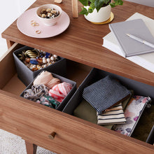 Gray cloth drawer organizer boxes filled with folded socks and small items