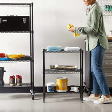 Black 3-shelf wire storage rack holding kitchen items, with leveling feet