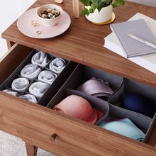 Gray drawer organizer in use with folded socks, underwear, and a bra in separate cells