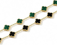 Gold-tone clover pendant bracelet set with green and black enamel motifs