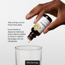 THORNE Vitamin D + K2 liquid bottle dispensing drops into a glass cup, 600 servings