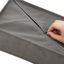 Gray fabric storage organizer with zipper along the top edge for secure closure