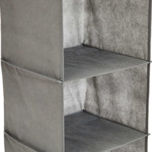 Gray hanging shelf organizer with open compartments and visible seams on fabric bins