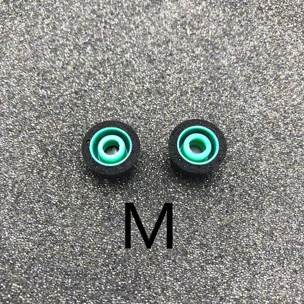 Pair of teal-green earbud eartips labeled M, with black foam outer sleeves.