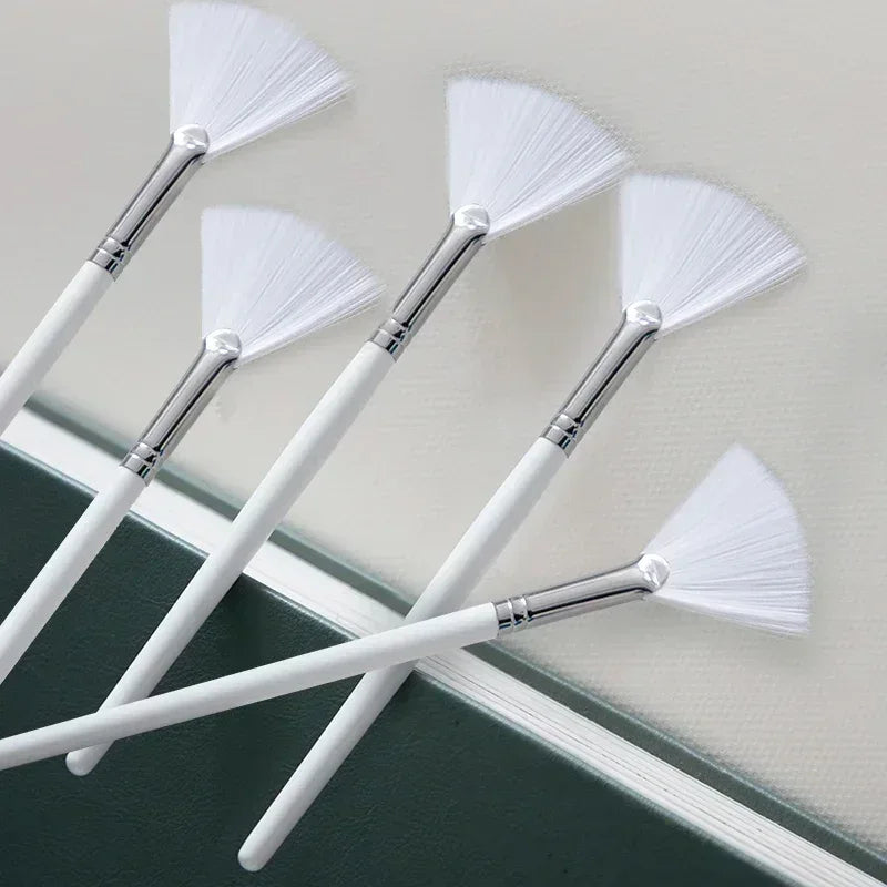 Face mask brush set with white handles and fan-shaped white bristles, silver ferrules