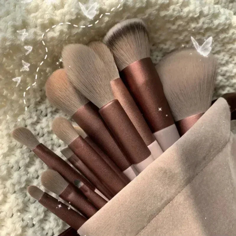 Makeup brushes with brown handles and taupe bristles, fanned arrangement on cloth