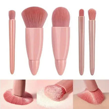 Five mini makeup brushes with rose-beige handles and dense rounded bristles