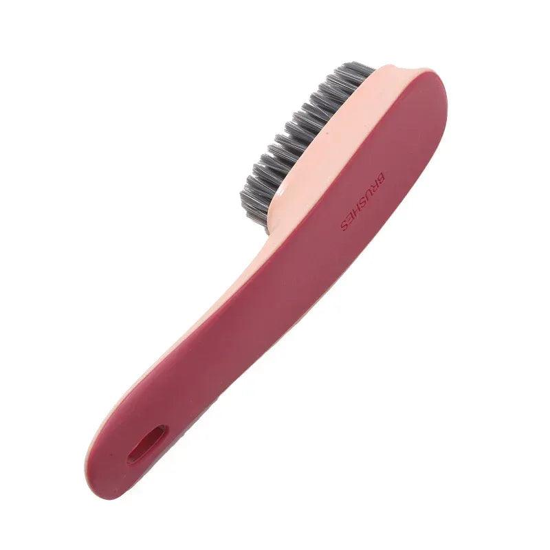 Shoe cleaning brush with maroon plastic handle and gray scrubbing bristles